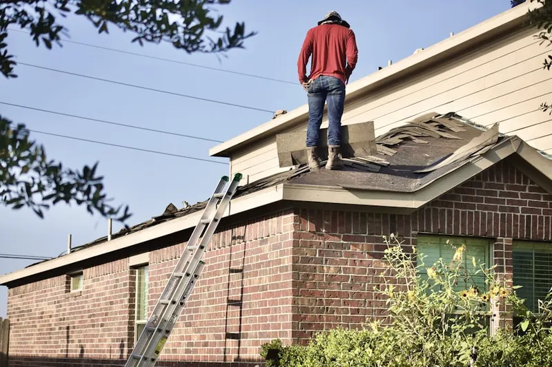 Professional roofer working on a residential roof in Delano